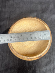 Wooden bowl with a ruler on a dark fabric background